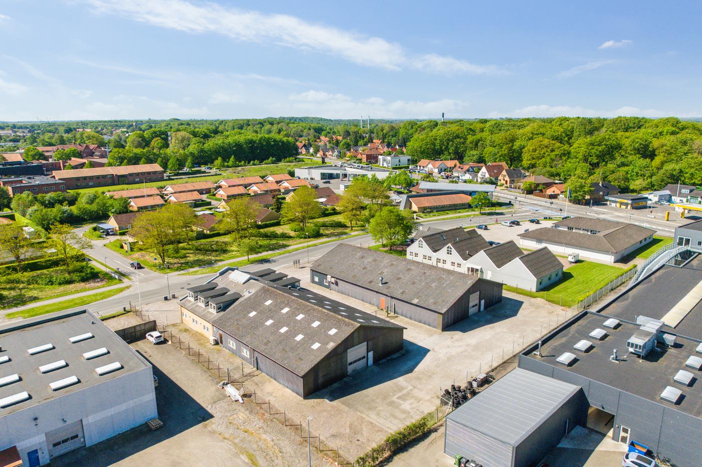 REInvest RoboHouse at Landbrugsvej 6 seen from the air, with Odense S and the forest beyond