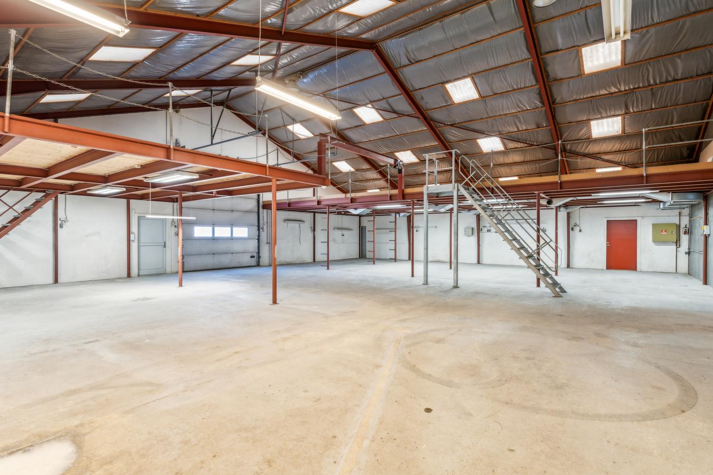 A steel-framed hall at Landbrugsvej 6 with a mezzanine and stair