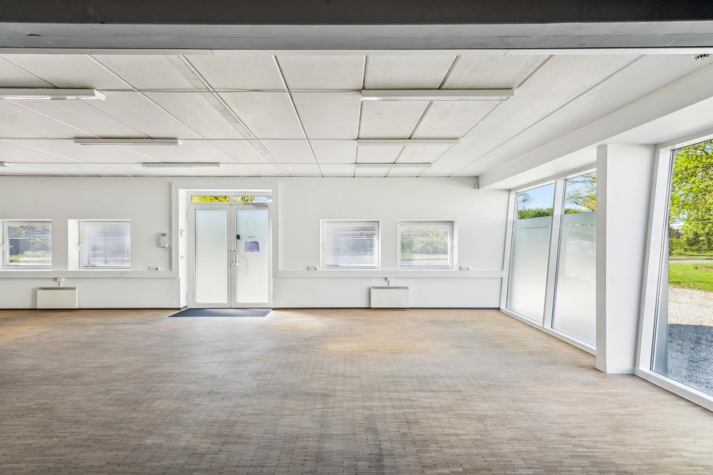 A glazed room at Landbrugsvej 6 with a window wall onto greenery