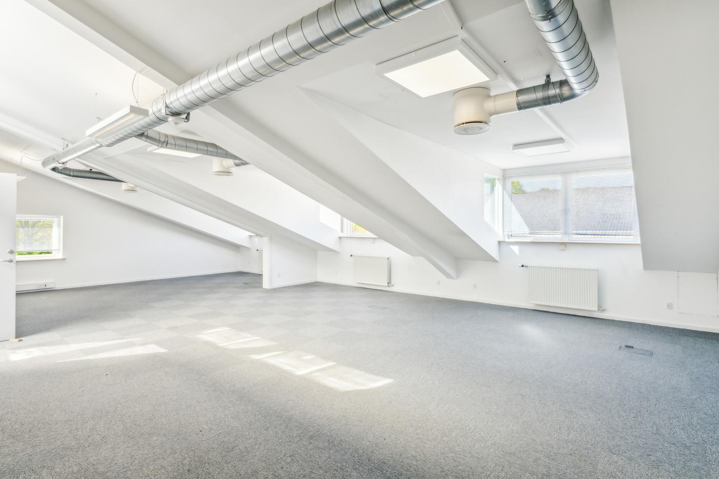 An empty upper-floor office room at Landbrugsvej 6 with daylight from dormer windows